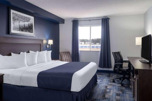 um quarto de hotel com uma cama, uma secretária e uma janela em Travelodge Suites by Wyndham Saint John em Saint John