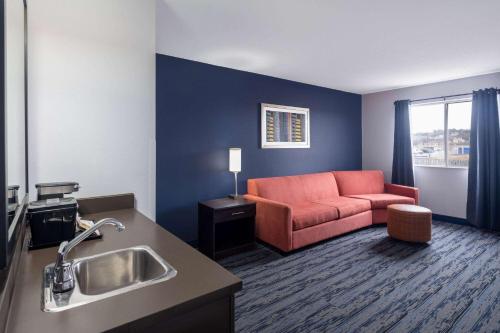 ein Wohnzimmer mit einem Sofa und einem Waschbecken in der Unterkunft Travelodge Suites by Wyndham Saint John in Saint John