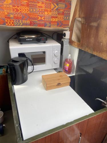 un forno a microonde seduto sopra un bancone in un camper di Nuit insolite dans un petit voilier a La Rochelle