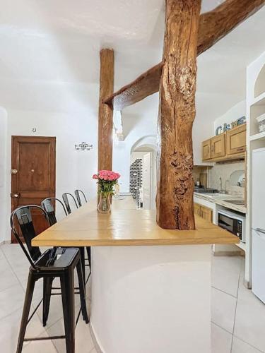 une cuisine avec une table avec un vase de fleurs dessus dans l'établissement Loft Spacieux au Cœur du Village, à Vence