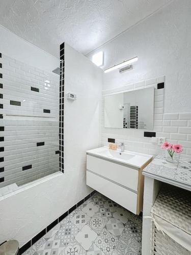 une salle de bain blanche avec un lavabo et un miroir dans l'établissement Loft Spacieux au Cœur du Village, à Vence