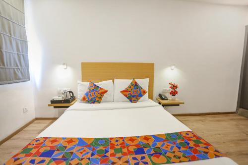 a bedroom with a large bed with a colorful blanket at FabHotel Vivek in Muthiganj