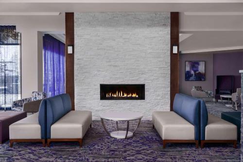 a lobby with two chairs and a fireplace at Hilton Garden Inn Calgary Airport in Calgary