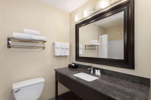 a bathroom with a sink and a mirror at Baymont by Wyndham Copley Akron in Copley