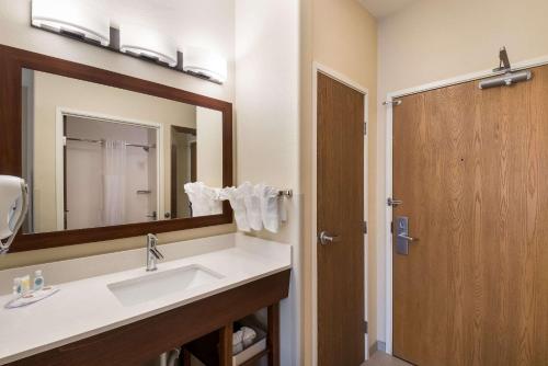 W łazience znajduje się umywalka i lustro. w obiekcie Comfort Inn Fort Morgan w mieście Fort Morgan