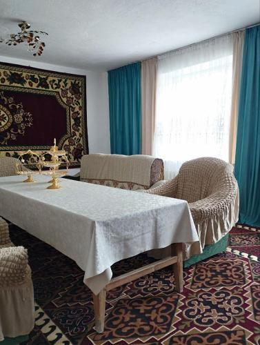 a room with a table and chairs and a window at Guest House Bereke in Kyzart village in Bagysh