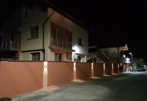 una recinzione di fronte a un edificio di notte di ViBo Guesthouse a Sapareva Banya