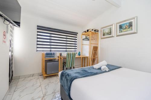 a bedroom with a bed and a desk at Zuri Place in East London