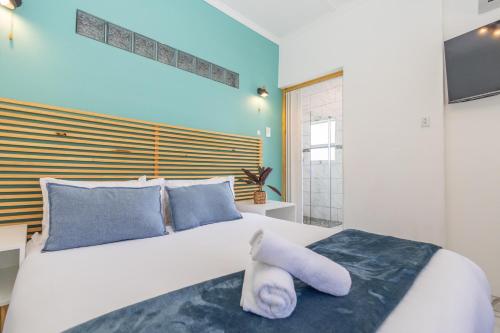 a bedroom with a large white bed with blue pillows at Zuri Place in East London