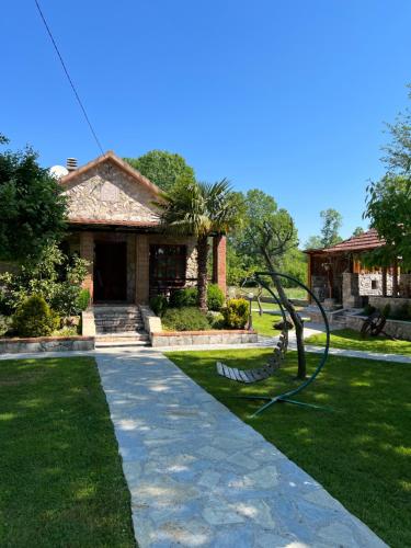 a house with a statue in front of a yard at Forest Home in Golubovci