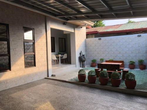a patio with potted plants and a table in a house at 3-Bedroom bungalow in San Fernando Pampanga in San Fernando