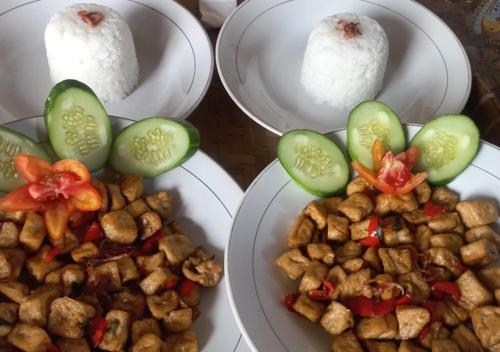 tres platos de comida con arroz y verduras. en Sarang Walet Homestay, en Tetebatu