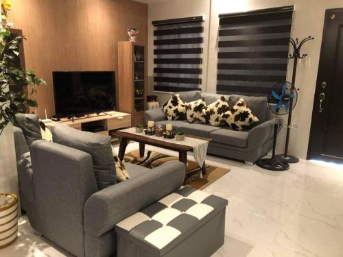 a living room with two couches and a table at 3-Bedroom bungalow in San Fernando Pampanga in San Fernando