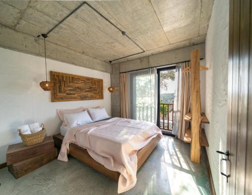 a bedroom with a bed and a large window at Kikonia Art & Suites in Akyaka