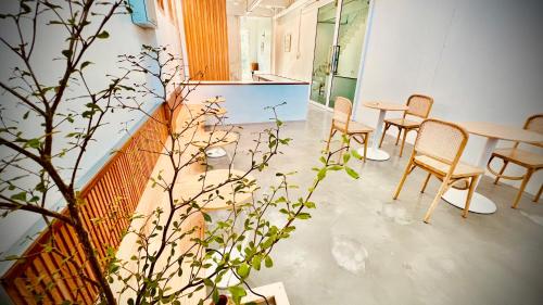 a room with chairs and a table and a plant at Momento Hotel and Cafe in Khon Kaen