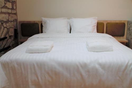 - un grand lit blanc avec 2 oreillers dans l'établissement Kalamaja Loft Apartments, à Tallinn