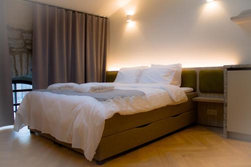 - une chambre avec un lit doté de draps et d'oreillers blancs dans l'établissement Kalamaja Loft Apartments, à Tallinn