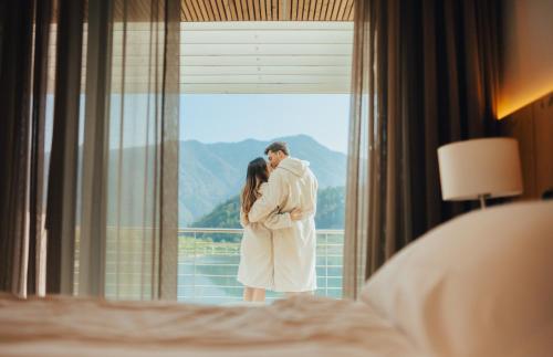 a man and a woman standing in front of a window at Parc Hotel Du Lac in Levico Terme