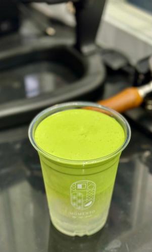 a green cup sitting on top of a counter at Momento Hotel and Cafe in Khon Kaen