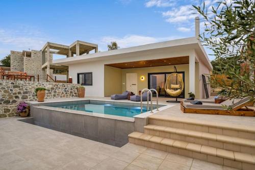 a villa with a swimming pool in front of a house at L'Maya Luxury Villa private pool, 2 Master BD, BBQ in Kalochorafitis