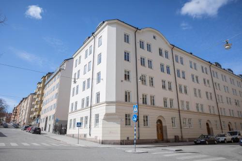 斯德哥爾摩的住宿－Lugn design lägenhet, i heta Sofo, Södermalm，街道拐角处的白色大建筑