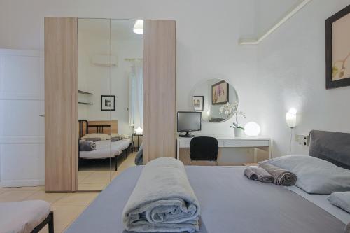 1 dormitorio con cama, escritorio y espejo en B&B Cristina Garden, en Pisa