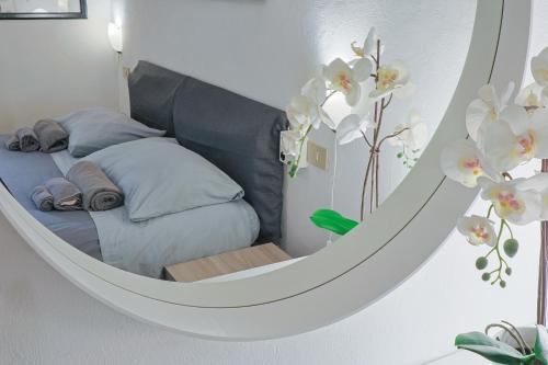 a bedroom with a bed in a round mirror at B&B Cristina Garden in Pisa