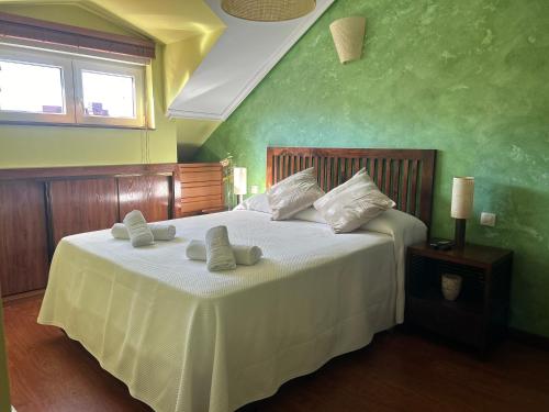 una camera da letto con un grande letto bianco con due asciugamani di HOLYDAY HOME SUANCES a Suances