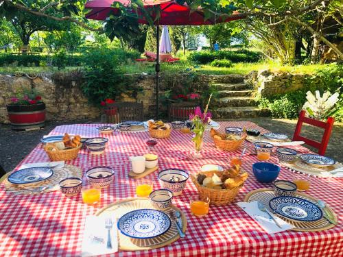 a picnic table with plates and baskets of food on it at Puechblanc Gîtes et Chambre d'hôte dans le Triangle d'or Gaillac-Albi-Cordes sur Ciel in Fayssac