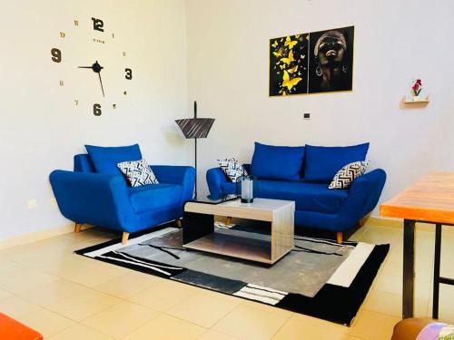 a living room with two blue couches and a table at Cool meublé in Ouagadougou