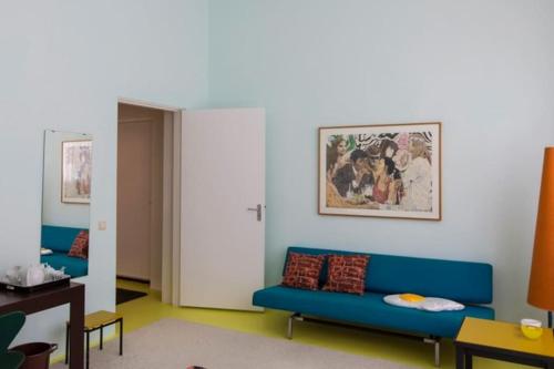 ein Wohnzimmer mit zwei blauen Sofas in einem Zimmer in der Unterkunft Westerpark Loft, private studio in Amsterdam