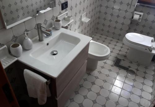 Baño blanco con lavabo y aseo en Camera Relax confortevole e riservata in villa, en Massa Lubrense