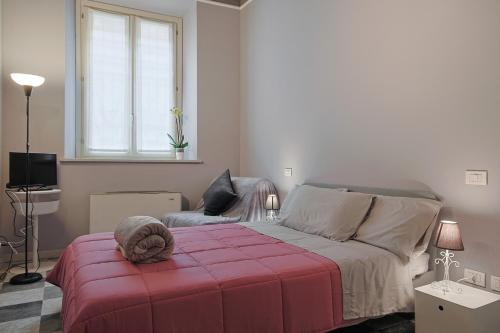 a bedroom with a bed and a chair and a window at Cristina e Elena Suite in Pisa