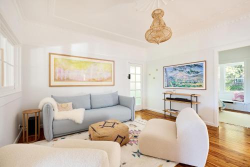 a living room with a couch and two chairs at Emerald Cottage in the Blue Mountains in Faulconbridge