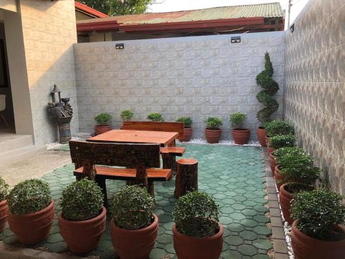 a patio with a wooden table and potted plants at 3-Bedroom bungalow in San Fernando Pampanga in San Fernando