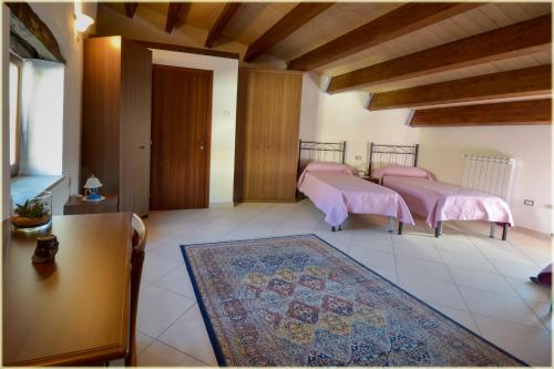 皮耶特拉佩爾托薩的住宿－Il Palazzo del Barone - Stanza dei Ravelli，一间铺有地毯的客房内的两张粉红色床铺