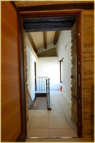 una puerta abierta a un pasillo con una escalera en una casa en Il Palazzo del Barone - Stanza dei Ravelli, en Pietrapertosa