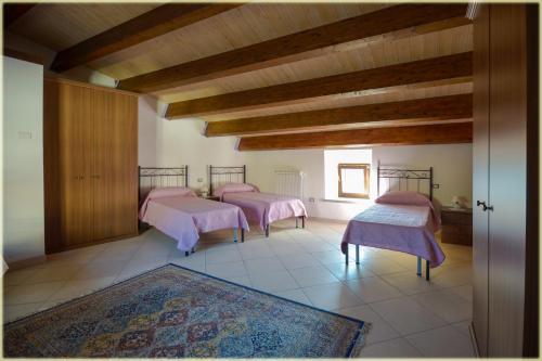 - 4 lits dans une chambre dotée de plafonds en bois dans l'établissement Il Palazzo del Barone - Stanza dei Ravelli, à Pietrapertosa