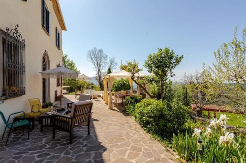 d'une terrasse avec une table et des chaises dans la cour. dans l'établissement gite 6 chambres en Toscane, à Serrazzano