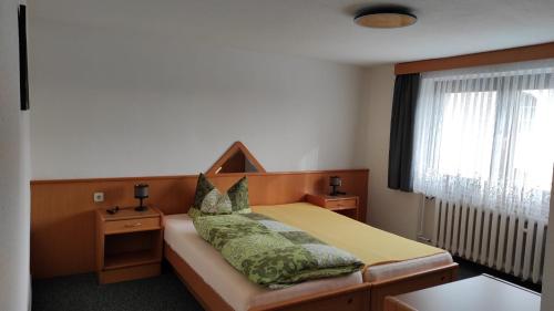 a bedroom with a bed with green pillows at Gasthof Zur Goldenen Sonne in Remptendorf