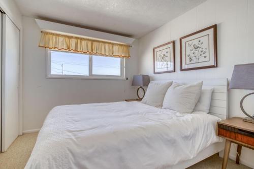 a white bedroom with a bed and a window at Sand and Sky in Bayshore
