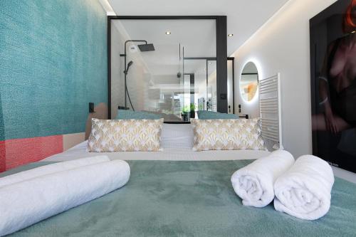 - une chambre avec 2 serviettes blanches sur un lit dans l'établissement Village Naturiste R4N - Le First Port Nature, au Cap d'Agde