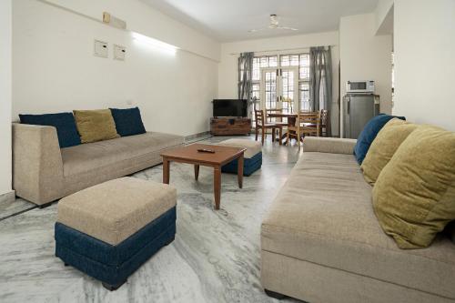 uma sala de estar com dois sofás e uma mesa em Aishwarya Mystic Apartotel em Bangalore