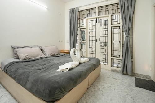 een slaapkamer met een bed met een wit dier erop bij Aishwarya Mystic Apartotel in Bangalore