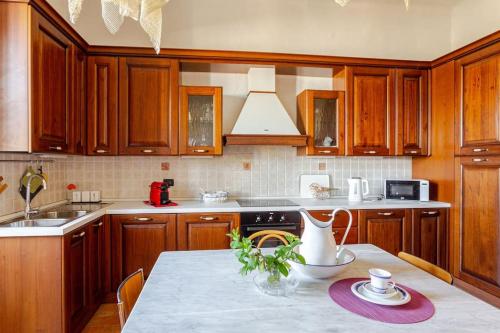 a kitchen with wooden cabinets and a table with a vase on it at gite Da Clara in Serrazzano