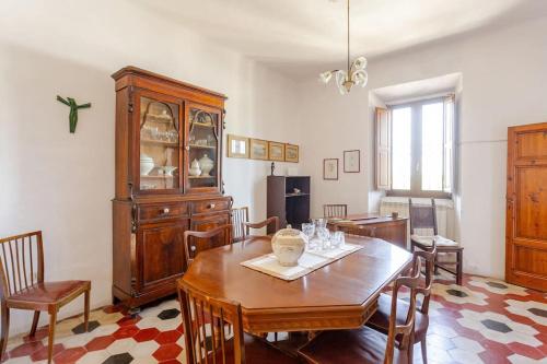 d'une salle à manger avec une table et une armoire en bois. dans l'établissement gite 6 chambres en Toscane, à Serrazzano