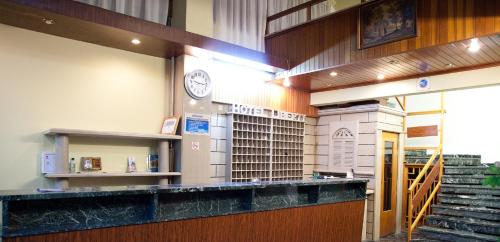 a library with a clock on the wall and stairs at Hotel Liberty in Mesolongion