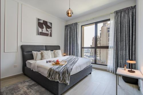 1 dormitorio con cama y ventana grande en Trophy - Countryside Bliss Suites en Dubái