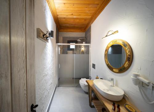 a bathroom with a sink and a mirror at Kikonia Art & Suites in Akyaka
