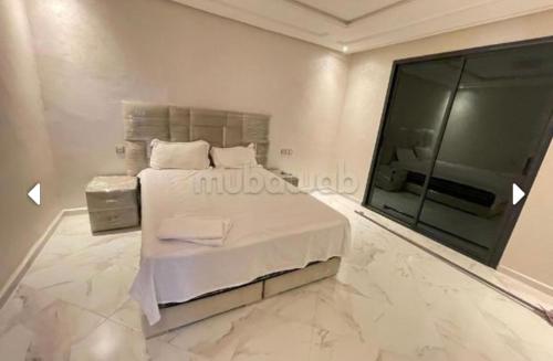um quarto com uma cama grande e uma janela grande em Sunny house em Tânger